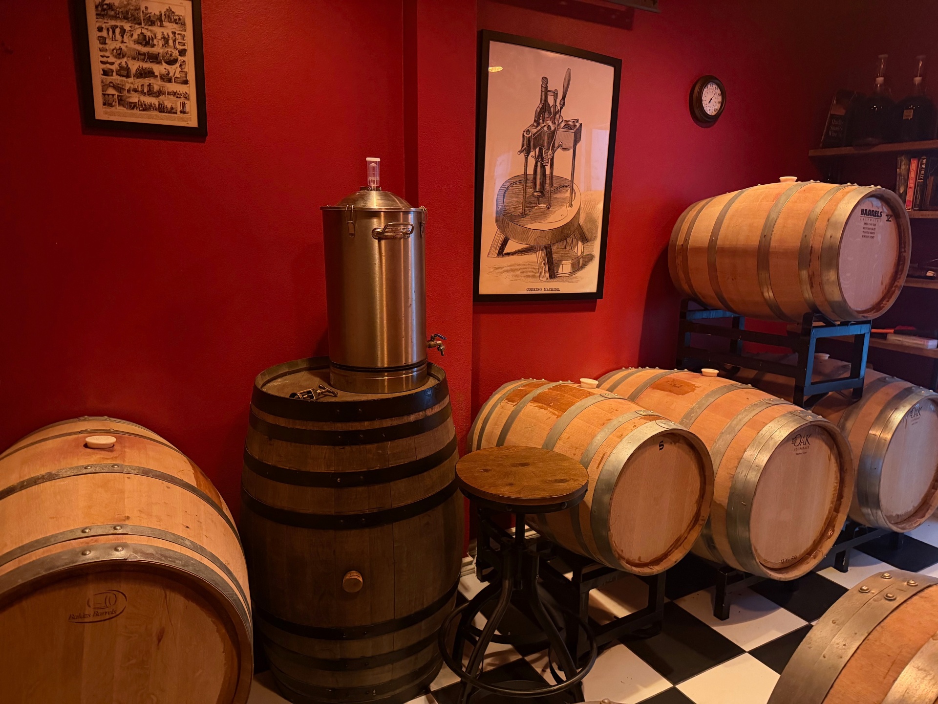 Casa Rogés cellar with deep red walls, checkerboard floor, and rows of oak barrels